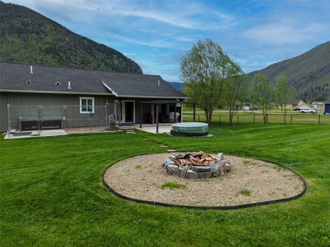 Rear view of property with a hot tub, a patio, a fire pit, and a mountain view | Image 40