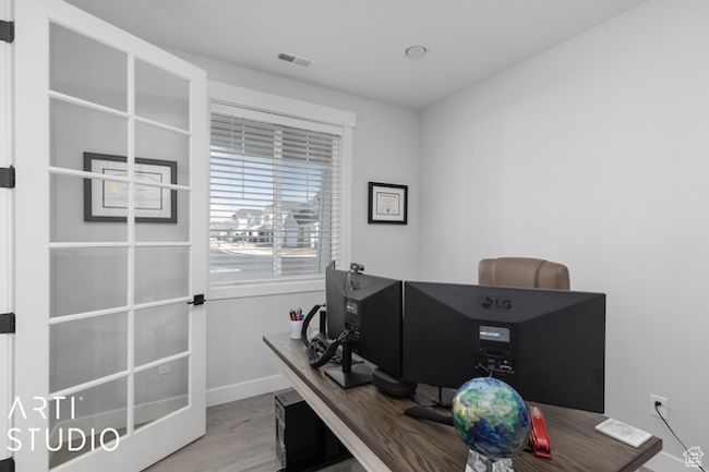 Office area featuring visible vents, baseboards, and wood finished floors | Image 8