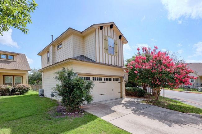 This charming two-story home features a two-car garage, driveway, and lush landscaping include crepe myrtle trees with vibrant summer blooms. | Image 7