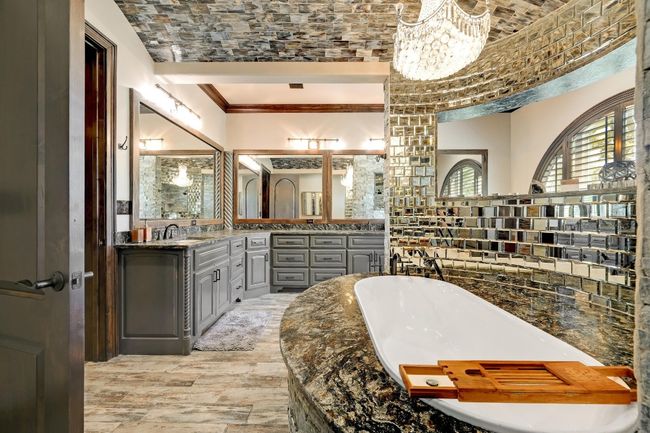 Full bath with a soaking tub, an inviting chandelier, ornamental molding, wood finished floors, and a sink | Image 26