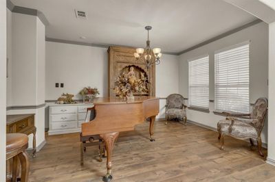 Home office featuring a notable chandelier, light hardwood / wood-style flooring, and crown molding | Image 3