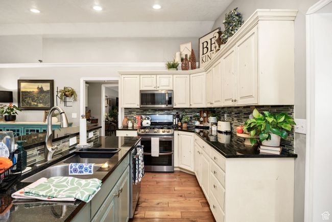 Kitchen with recessed lighting, backsplash, a sink, light wood-style flooring, and appliances with stainless steel finishes | Image 9
