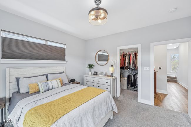 carpeted bedroom with a walk in closet, baseboards, and a closet | Image 14