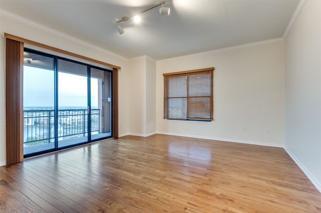 Sunlight streams into this end-unit sanctuary through expansive windows beneath soaring 10-foot ceilings, dancing across the rich hardwood floors and infusing every corner with a warm, welcoming glow. | Image 18