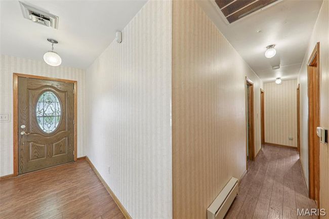 Foyer featuring hardwood / wood-style flooring, wallpapered walls, and a baseboard radiator | Image 11