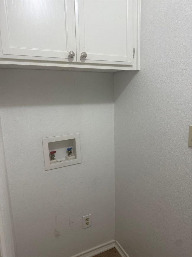 Washroom with hookup for a washing machine, cabinet space, and baseboards | Image 25