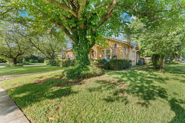 View of side of home featuring a yard, brick siding, central AC, and a chimney | Image 5