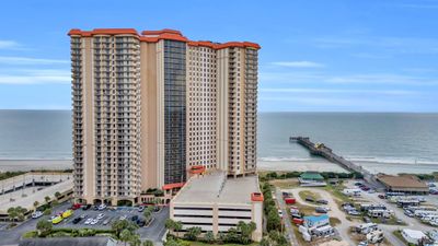 View of building exterior featuring a water view and a view of the beach | Image 1