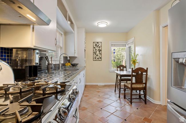 Kitchen featuring extractor fan, stainless steel fridge, range, and plenty of natural light | Image 5