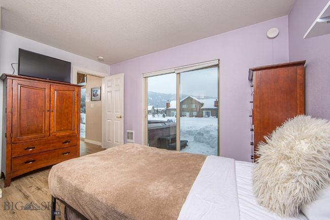Primary bedroom on main level with adjacent patio and hot tub | Image 14