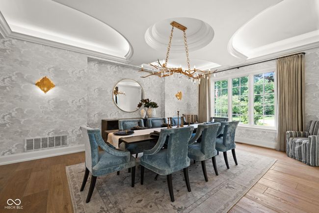 dining space featuring a chandelier and a tray ceiling | Image 11