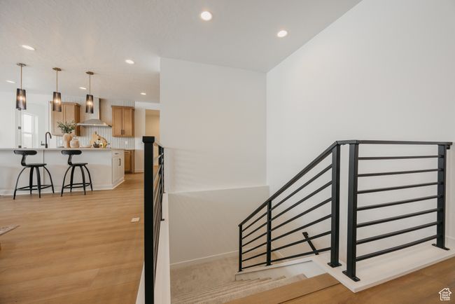 Staircase with wood finished floors and recessed lighting | Image 34