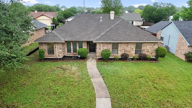 View of front of property featuring roof with shingles, a front lawn, and brick siding | Image 25