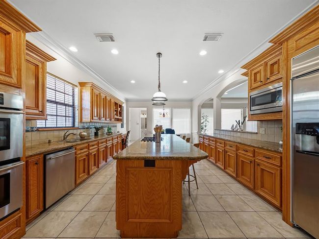 Spacious kitchen featuring a huge island with a brand new gas cooktop. | Image 20