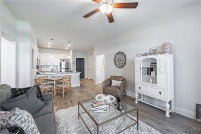 Living room with dark wood-type flooring, ceiling fan, and sink | Image 2