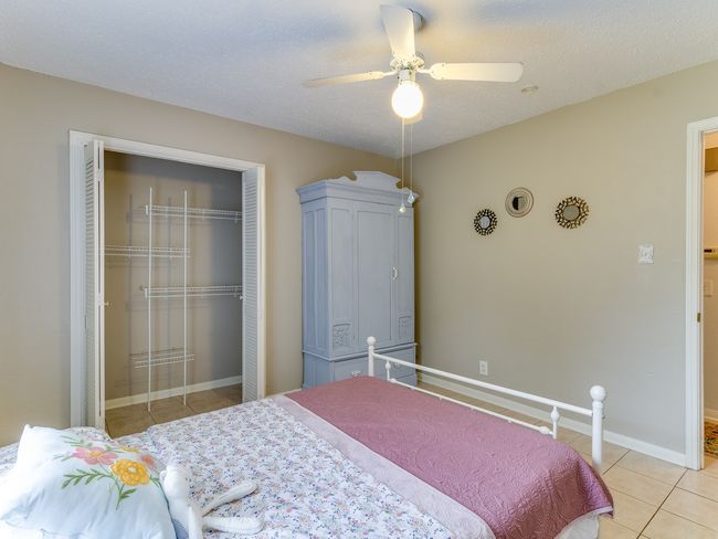 Bedroom with light tile patterned floors, a closet, and ceiling fan | Image 18