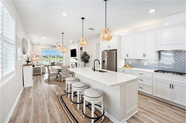 Fantastic kitchen with pantry, large island, stainless steel upgraded Whirlpool appliances, soft blue subway tile backsplash, upper and lower cabinet lighting and so much more! | Image 7