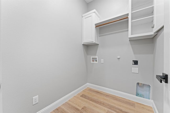 Laundry room with gas dryer hookup, hookup for an electric dryer, light wood-type flooring, cabinet space, and hookup for a washing machine | Image 25