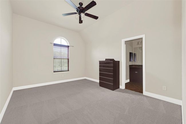This upstairs bedroom features soft carpeting, a tall window, and its own bathroom access. A closet near the vanity area adds storage and daily ease. | Image 39