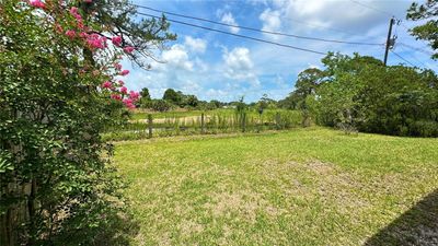 Backyard view facing out to empty field | Image 2