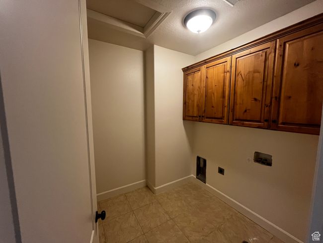 Laundry area featuring electric dryer hookup, cabinet space, attic access, hookup for a washing machine, and a textured ceiling | Image 11