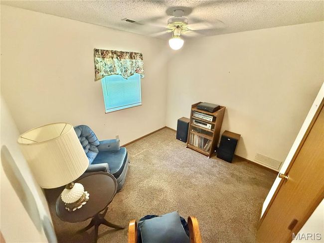 Living area with a ceiling fan, carpet floors, and a textured ceiling | Image 27