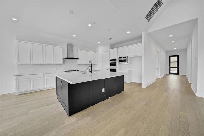 Elegant stainless steel double oven with dedicated microwave and appliance storage. | Image 15