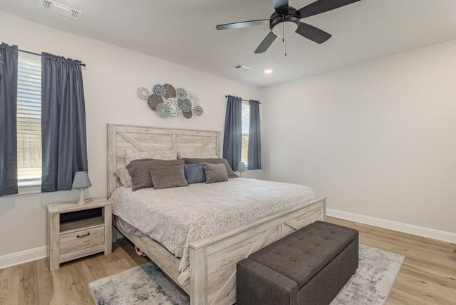 Bedroom featuring light wood finished floors, a ceiling fan, and recessed lighting | Image 13