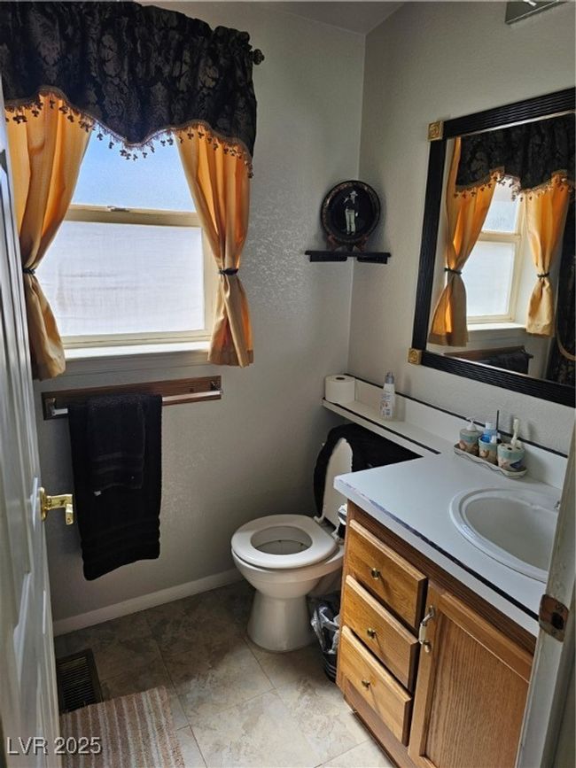 Half bathroom featuring baseboards, visible vents, toilet, and vanity | Image 20