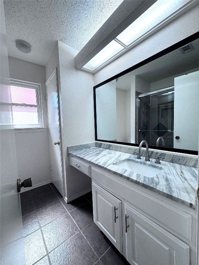 Full bath featuring vanity, a textured ceiling, a shower stall, and a textured wall | Image 22