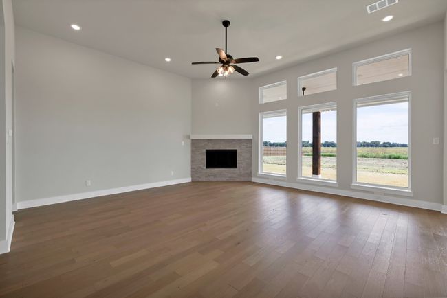 Unfurnished living room with a stone fireplace, recessed lighting, wood finished floors, and ceiling fan | Image 8