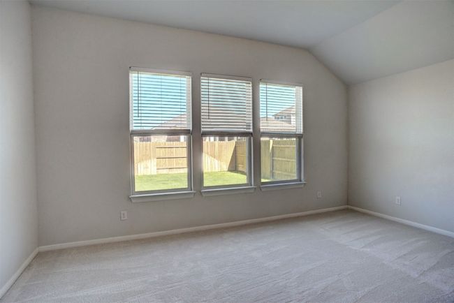 Carpeted empty room with vaulted ceiling and baseboards | Image 19