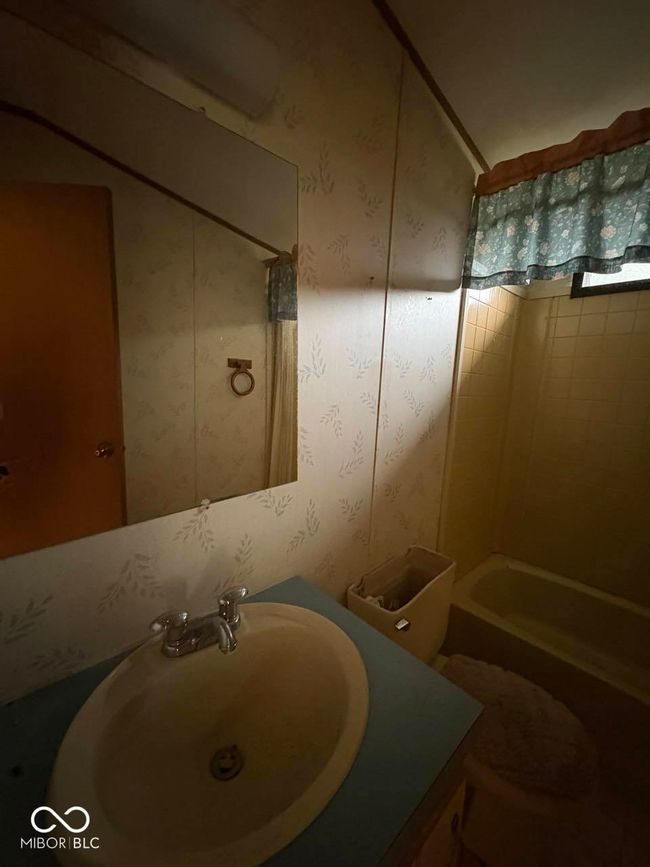 bathroom with vanity, wallpapered walls, and shower combination | Image 19