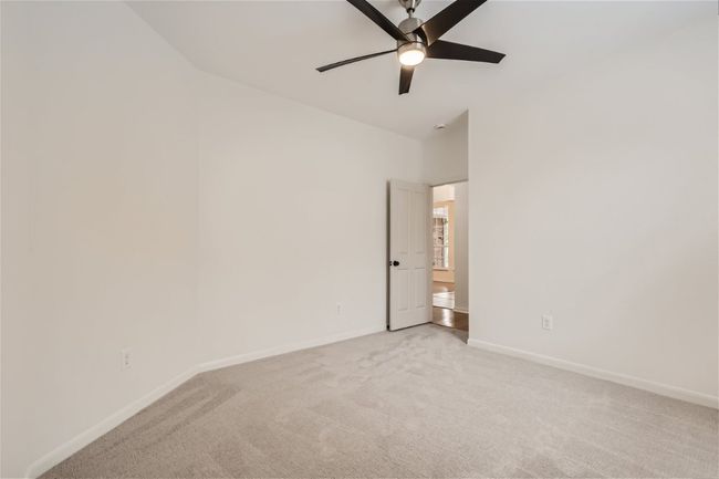 Unfurnished room with light colored carpet, baseboards, and ceiling fan | Image 23