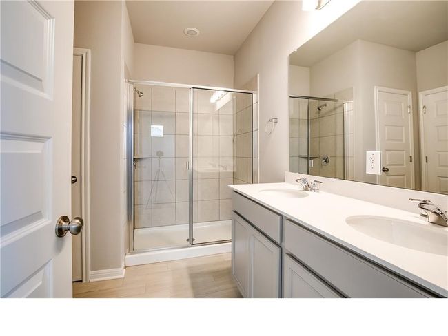 Bathroom featuring a stall shower and double vanity | Image 17