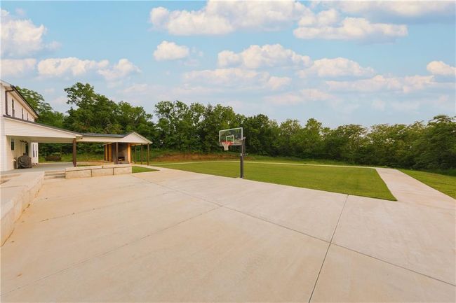 View of patio / terrace featuring concrete driveway. Lighting is installed for those late pick up games in the back. | Image 68