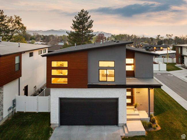 Contemporary house with a mountain view, driveway, fence, a garage, and a front yard | Image 45