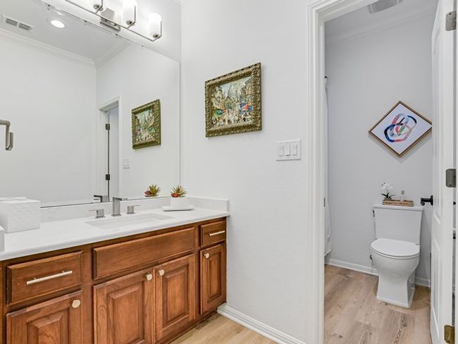 Bathroom featuring visible vents, crown molding, toilet, wood finished floors, and vanity | Image 18