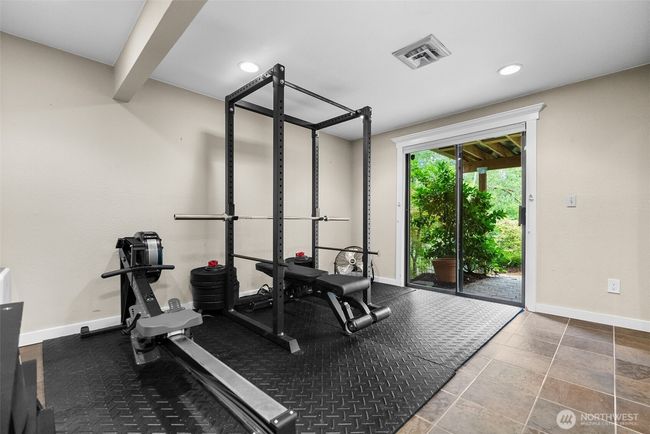 Lower level 3rd bedroom with heated floors and sliding door to patio | Image 25