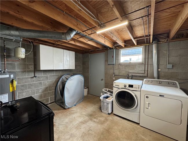 Laundry area featuring washing machine and dryer and water heater | Image 41