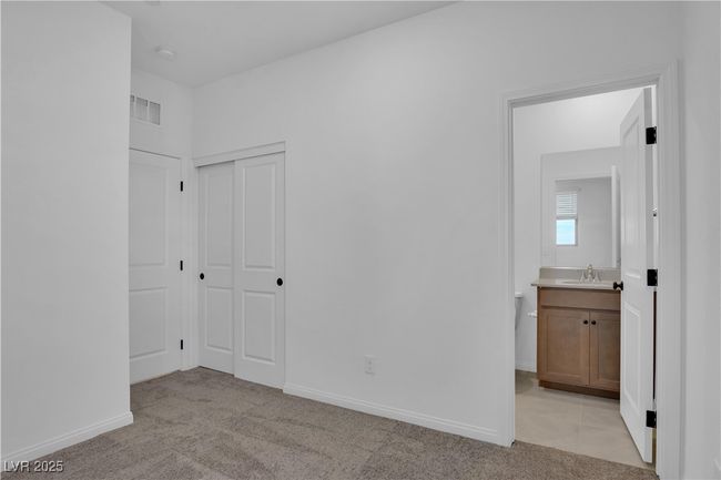 Unfurnished bedroom featuring a sink, visible vents, light carpet, and baseboards | Image 4