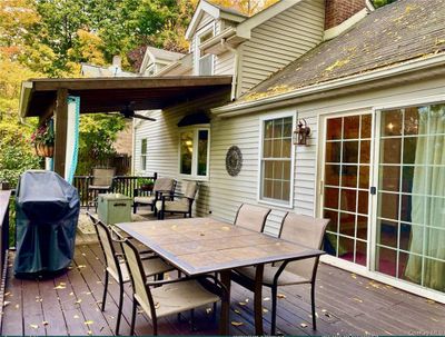 Deck featuring outdoor dining and grilling area & covered lounging area | Image 2