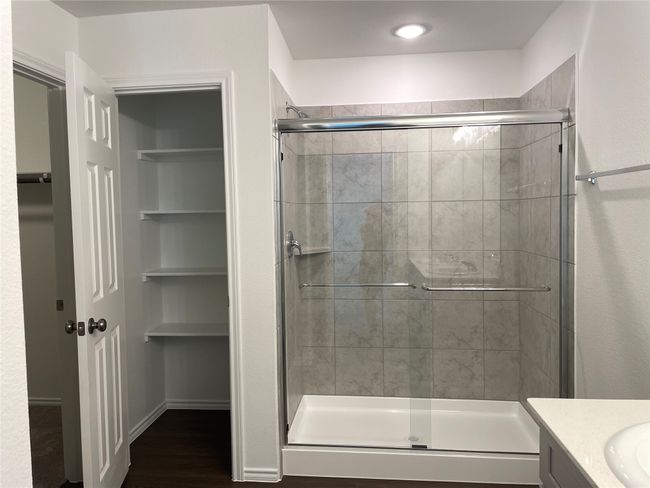 Full bathroom featuring a shower stall, vanity, and wood finished floors | Image 16