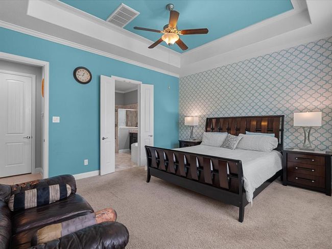 The primary bedroom is large with sitting area, an enjoining primary bath, tray ceiling and large windows, allowing for lots of natural light. | Image 22