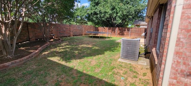 Fenced backyard featuring a trampoline | Image 14