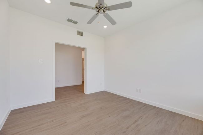 Empty room featuring light wood-style flooring, recessed lighting, and ceiling fan | Image 7