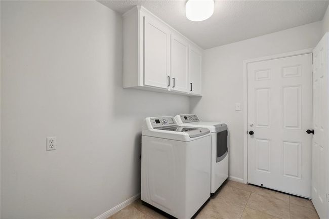 The functionally located laundry-room between the kitchen and the hallway to the garage includes enough space for an additional refrigerator and includes built-in storage space. | Image 19