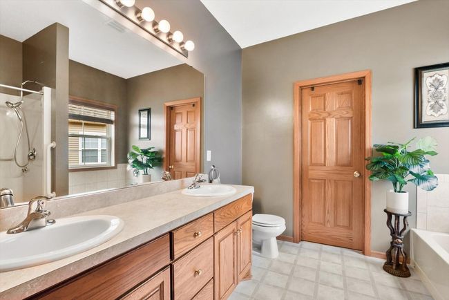 Spacious ensuite bathroom featuring a double oak vanity, large mirror, and beautiful paneled oak doors. | Image 28
