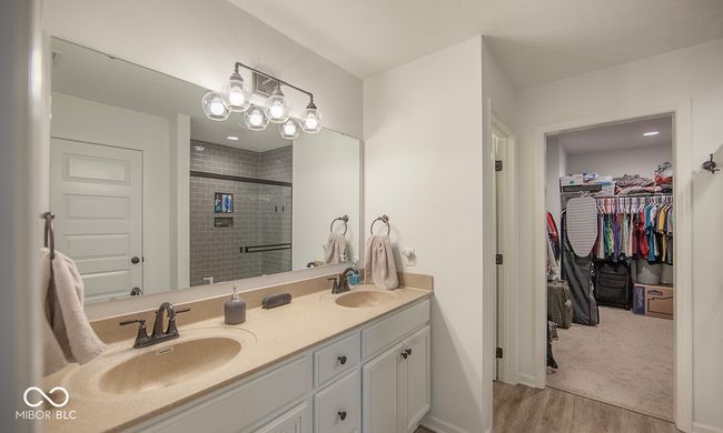 full bathroom with wood finished floors, a sink, a shower stall, and double vanity | Image 11