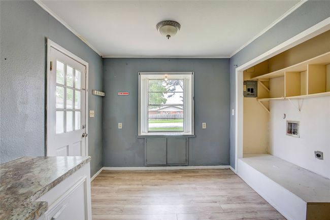 Doorway featuring light wood-style flooring, plenty of natural light, crown molding, and baseboards | Image 9